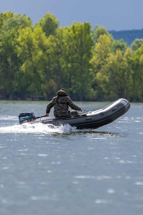 Barca inflable Barca Fox 320x en acción, navegando en el agua, ideal para carpfishing y actividades al aire libre.